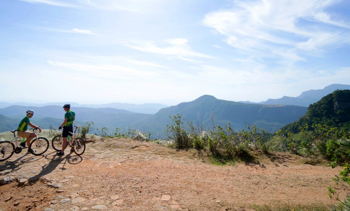 Two cyclists parked at viewpoint overlooking mountains of Sri Lanka