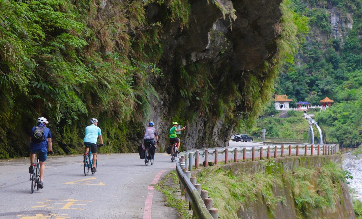 Three cyclists following guide around corner