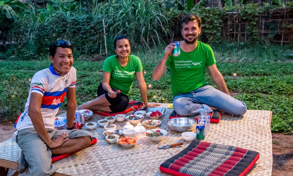 Guide and two travelers eating picnic outside in Cambodia