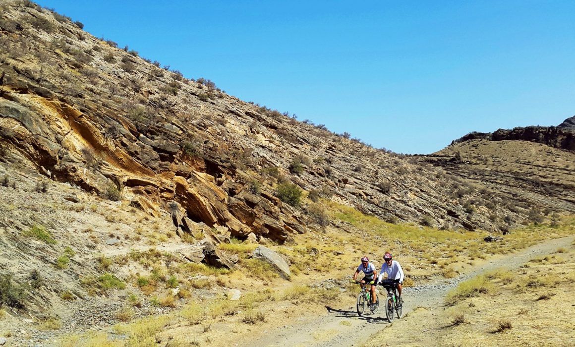 Two cyclists riding on gravel path