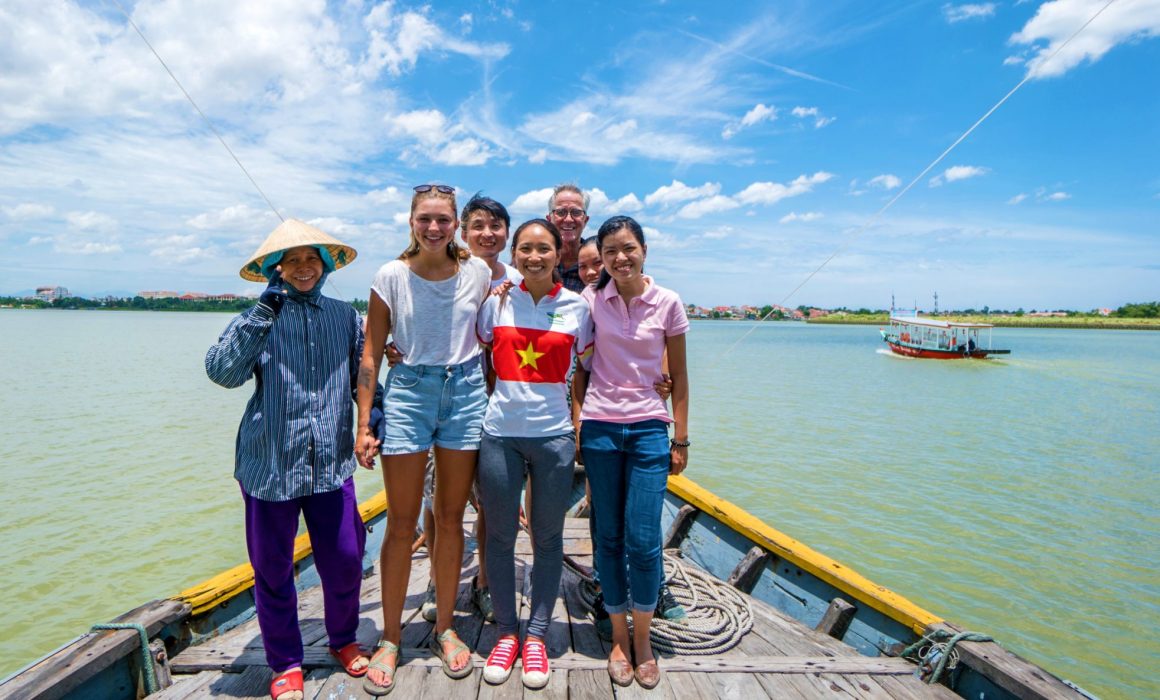 Steve, young woman and locals on boat in Vietnam