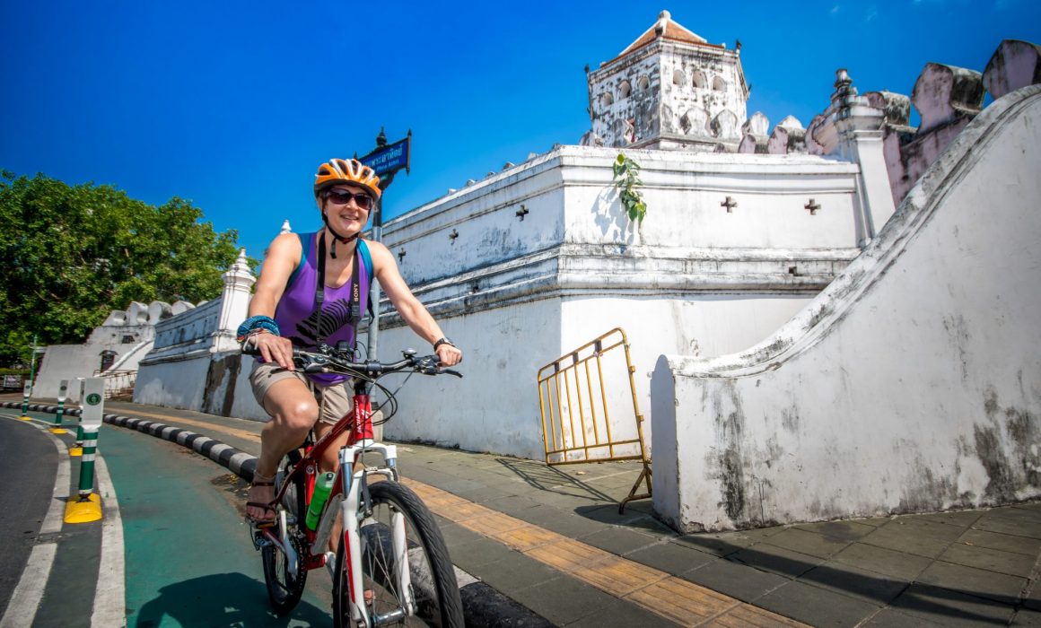 Female cyclist riding past Phra Sumen Fort in Bangkok