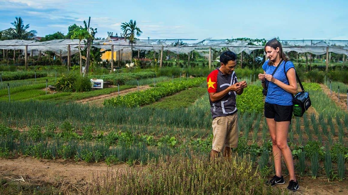 Guide and tourist woman at farm inspecting something in their hands