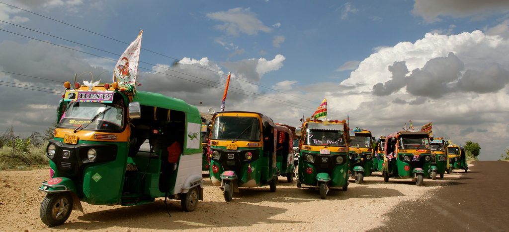 Yellow and green rickshaws on road in India