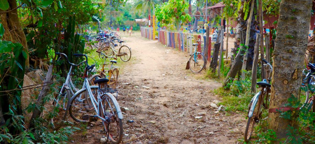 Bicycles along dirt path near fence