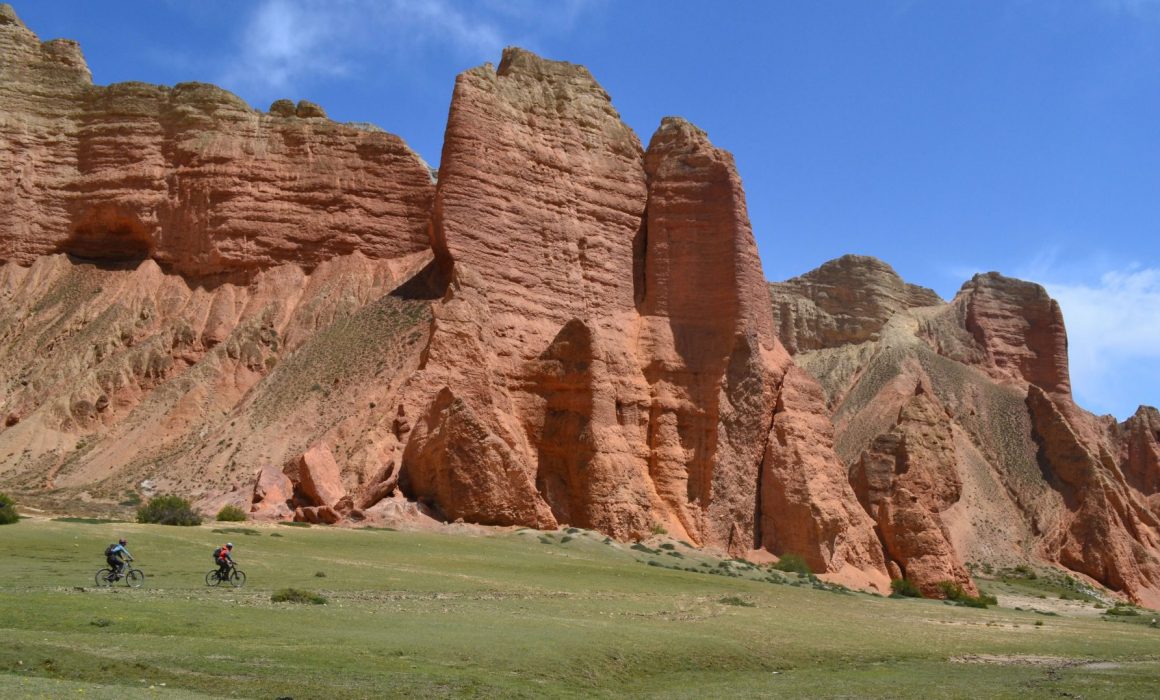 Red rocks with cyclists riding beneath them