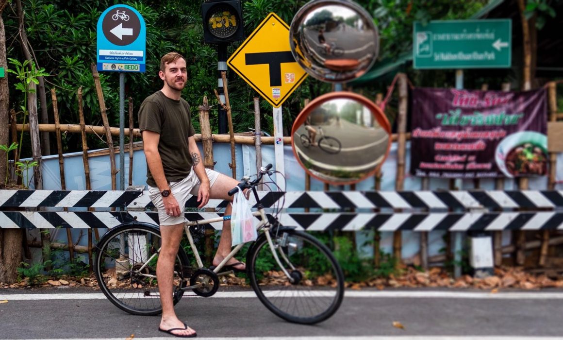 Jake on bicycle in front of street signs