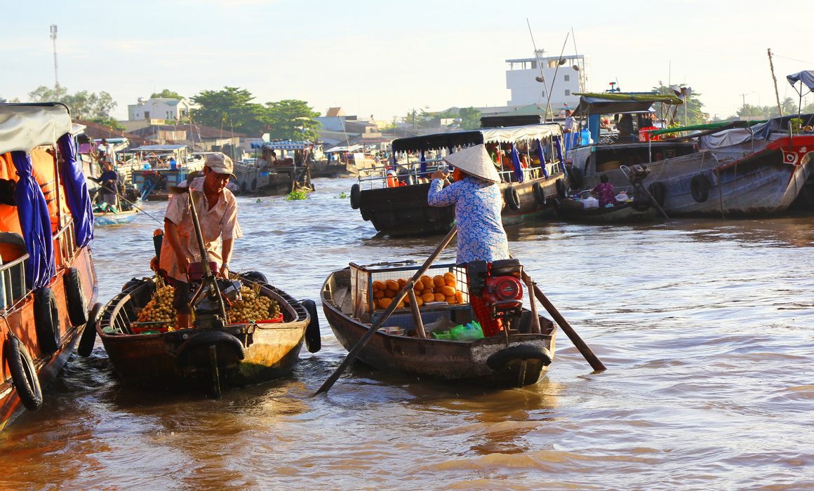 Two food vendors in boats on the Mekong River in Vietnam